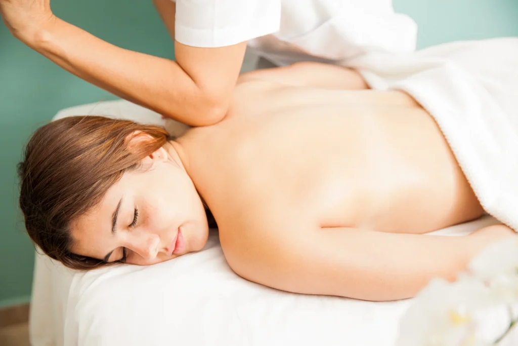 relaxed-young-woman-getting-deep-tissue-massage-by-female-therapist-health-clinic-seen-up-close